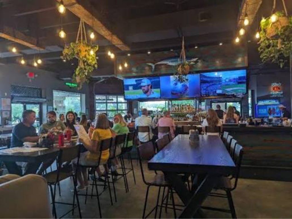 The Porch bar interior with big-screen TVs showing sports and guests at tables