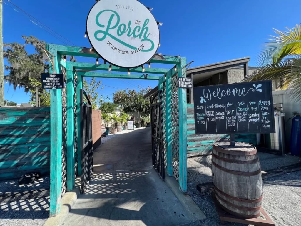 The Porch Winter Park entrance — teal wooden arch with round sign, est. 2014